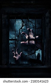Zombie hand rising out from old damaged wood window with wall over cross, church, dead tree, full moon and spooky cloudy sky, Halloween mystery concept