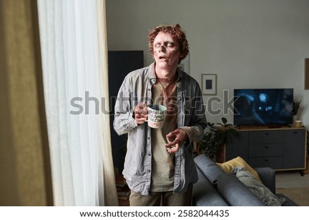 Zombie Man Drinking Coffee while Looking out of Window