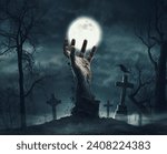 Zombie rising from the grave: creepy hand coming out of the ground and old tombstones