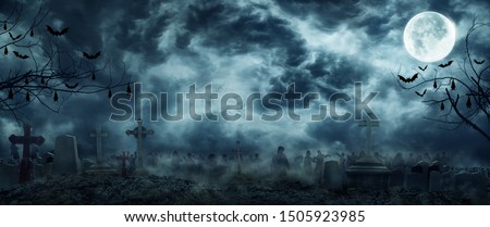 Zombie Rising Out Of A Graveyard cemetery In Spooky scary dark Night full moon bats on tree. Holiday event halloween banner background concept. 