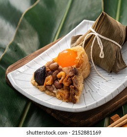 Zongzi. Rice dumpling for Chinese traditional Dragon Boat Festival (Duanwu Festival) on green leaf background with ingredient.