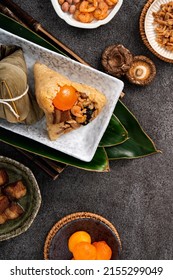 Zongzi, rice dumpling for Chinese traditional Dragon Boat Festival (Duanwu Festival) on dark gray table background with ingredient.