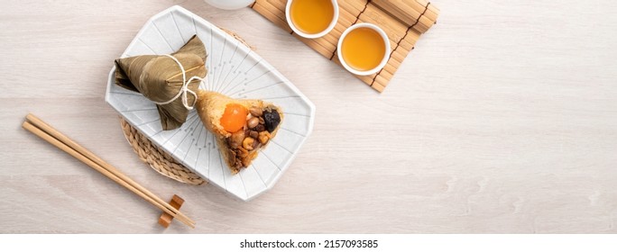 Zongzi. Rice dumpling for Chinese traditional Dragon Boat Festival (Duanwu Festival) on bright wooden table background with ingredient.