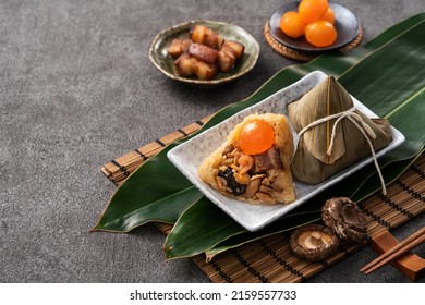 Zongzi, rice dumpling for Chinese traditional Dragon Boat Festival (Duanwu Festival) on dark gray table background with ingredient.