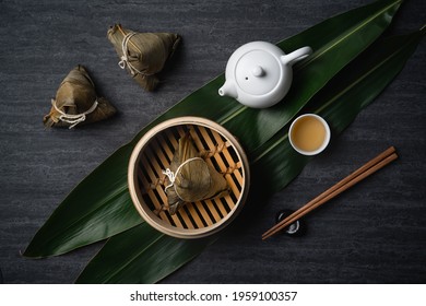 Zongzi Rice dumpling top view for Chinese traditional Dragon Boat Festival (Duanwu Festival) over dark black slate background.