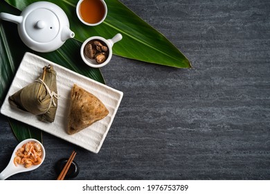 Zongzi. Rice dumpling top view design concept for Chinese traditional Dragon Boat Festival (Duanwu Festival) over dark black slate background.