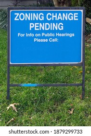 ZONING CHANGE PENDING sign in lawn of residential home. Copy space.