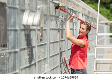 Zookeeper Woman Working On Cleaning Cage In Animal Shelter With Sweep 