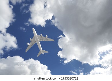 Zoom photo from ground level of passenger plane flying above deep blue cloudy sky