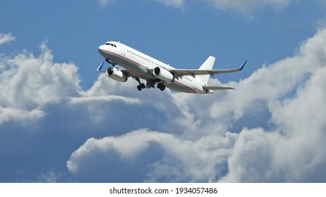 Zoom Photo Of Passenger Airplane Taking Off Reaching Altitude Above Clouds In Deep Blue Sky