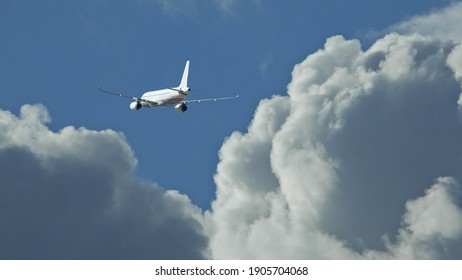 Zoom Photo Of Passenger Plane Flying Above Deep Blue Cloudy Sky