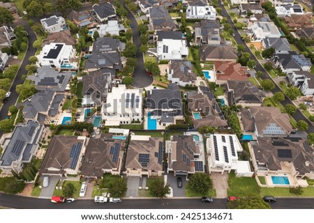 Zoomed out aerial view of an upmarket neighbourhood with modern prestige homes on a cul-de-sac with rooftop solar and pools in outer suburban Sydney, Australia.