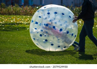 Zorb For Kids. Children roll inside the ball on the field.