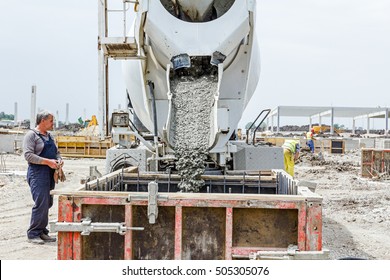 Zrenjanin, Vojvodina, Serbia - May 21, 2015: Workers at building site are pouring concrete in mold from mixer truck.
