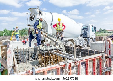 Zrenjanin, Vojvodina, Serbia - May 29, 2015: Workers at building site are pouring concrete in mold from mixer truck.