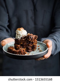 Zucchini and chocolate cake with ice cream and berries in the hands