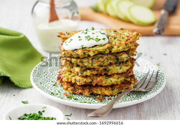 Zucchini fritters, vegetarian zucchini\
pancakes, served with fresh herbs and sour\
cream.