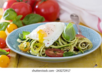 Zucchini Noodles With Tomatoes And Pesto With Egg On Top