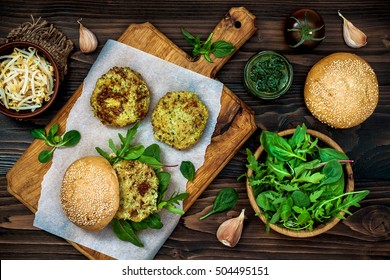 Zucchini Quinoa Veggie Burger With Pesto Sauce And Sprouts. Vegetarian Burger On A Cooking Sheet Ready To Prepare Hamburger. Top View, Overhead, Flat Lay