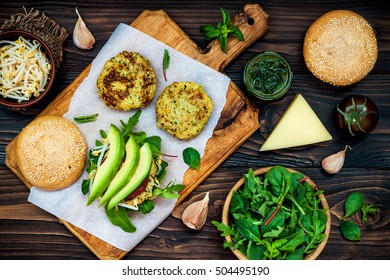 Zucchini Quinoa Veggie Burger With Pesto Sauce And Sprouts. Vegetarian Burger On A Cooking Sheet Ready To Prepare Hamburger. Top View, Overhead, Flat Lay