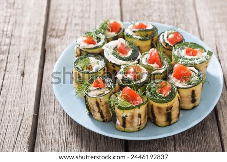 Zucchini rolls with cream cheese , tomatoes and dill . Healthy vegetarian food background