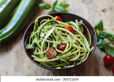 Zucchini spaghetti with rough basil and walnut pesto and cherry tomatoes - Powered by Shutterstock