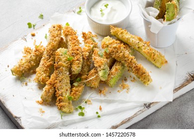 Zucchini sticks in breadcrumbs, with cheese, herbs, breadcrumbs and white yogurt sauce. Healthy tasty snack, summer food
