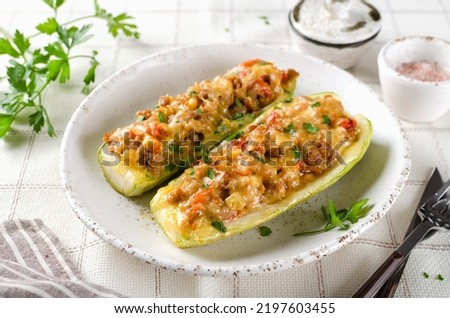 Zucchini stuffed with minced meat and tomatoes and cheese. Baked in the oven.