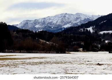 The Zugspitze Mountain Range, Germany’s highest, rises dramatically above the snow-covered fields of Garmisch, creating a breathtaking winter panorama. 