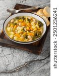 Zuppa Frantoiana Bean and Vegetable Soup closeup on the bowl on the wooden board. Vertical
