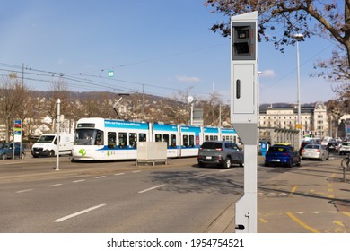 Zurich, Switzerland - March 10, 2021: evening Road traffic: speed and red light radar in one device, white streetcar in background, by day
