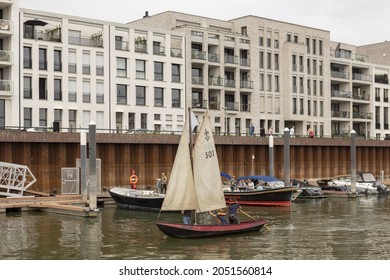 ZUTPHEN, NETHERLANDS - Aug 21, 2021: Picturesque Small Historic Sailboat Barge Leaving Recreational Port In Noorderhaven Neighbourhood Passing Contemporary Modern Apartment Building