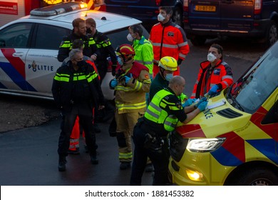 Zutphen, The Netherlands - December 8, 2020: Early morning meeting of task force of ambulance personnel, police and fire fighters in face masks deliberating and organizing at an accident scene