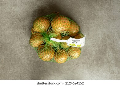 Zutphen, Netherlands - January 2022: Top Down View With Spotlight On Biological Onions With Leek Growing Against A Modern Contemporary Kitchen Gray Studio Backdrop. Studio Food Industry Still Life.