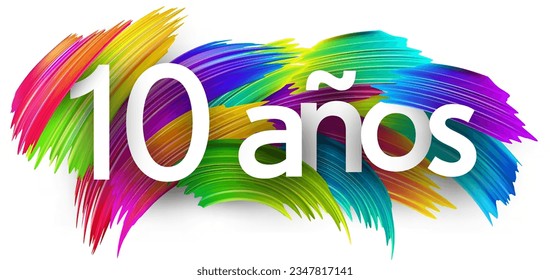 10 years at spanish paper word sign with colorful spectrum paint brush strokes over white. Vector illustration.