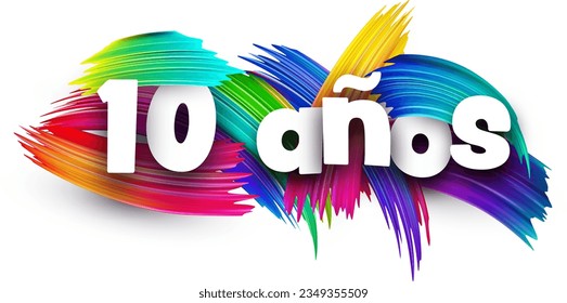 10 years at spanish paper word sign with colorful spectrum paint brush strokes over white. Vector illustration.