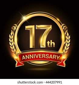 17th golden anniversary logo, with shiny ring and red ribbon, laurel wreath isolated on black background, vector design