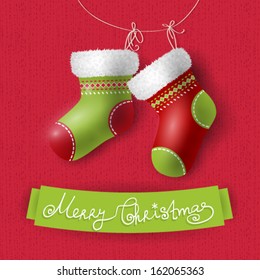 2 Christmas socks on red textured background and white grunge frame, Christmas background