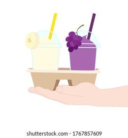 The 2 glasses of juice smooties (grape, banana). They are in the cup carier that hold in hand. take a way beverages. home delivery concept. organic and healthy soft drink for summer.