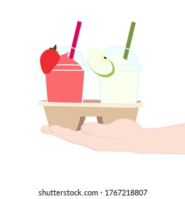 The 2 glasses of juice smooties (strawberry, apple). They are in the cup carier that hold in hand. take a way beverages. home delivery concept. organic and healthy soft drink for summer.