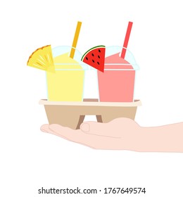 The 2 glasses of juice smooties (watermelon, pineapple). They are in the cup carier that hold in hand. take a way beverages. home delivery concept. organic and healthy soft drink for summer.
