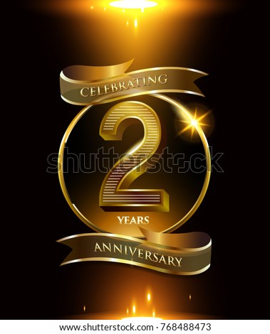 2 years anniversary logo with shiny ribbon and golden ring isolated on black background