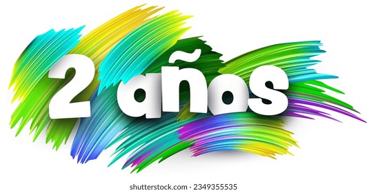 2 years at spanish paper word sign with colorful spectrum paint brush strokes over white. Vector illustration.