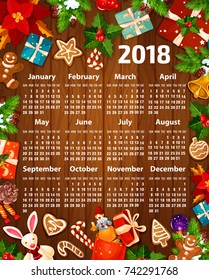 2018 calendar design of Christmas and New Year decorations, Santa gifts and Christmas tree garland. Vector calendar template of golden bell on holly wreath, gingerbread cookie and winter snowflakes