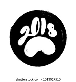 2018 year sign on the round stamp with rough borders. Calligraphy with bold brush strokes in the form of dog paw