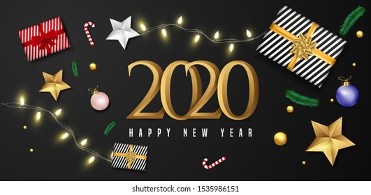 2020 Happy New Year greeting card design with top view of baubles, gift box, stars and lighting garland decoration on black background.