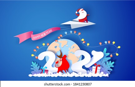 2021 New Year card design. Santa Claus flying on paper airplane over globe Earth on blue background. Vector paper cut art illustration for promotion banners, headers, posters, stickers