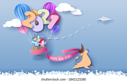 2021 New Year design card with kids in basket of air balloons flying on blue sky background and bull running with red ribbon. Vector paper art illustration. Paper cut and craft style.