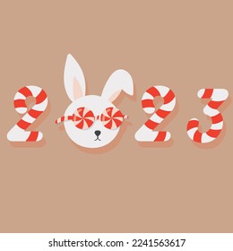 2023. cute New Year's rabbit in glasses in the form of candies. New Year's card with a rabbit.