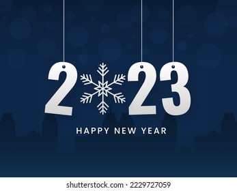 2023 Number Hang With Snowflake Against Blue Silhouette Buildings Background.